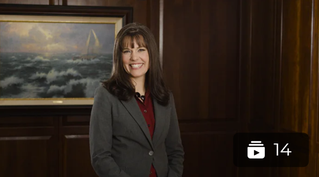 Carmen is wearing a suit jacket and smiling at the camera.